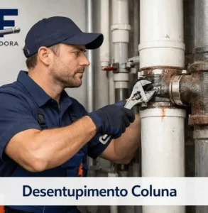 Técnico da desentupidora realizando desentupimento de coluna predial de esgoto.
