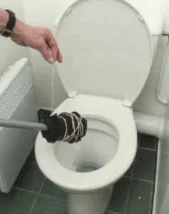 Profissional da nossa desentupidora demonstra um método incorreto de desentupir vaso sanitário para orientar os clientes.